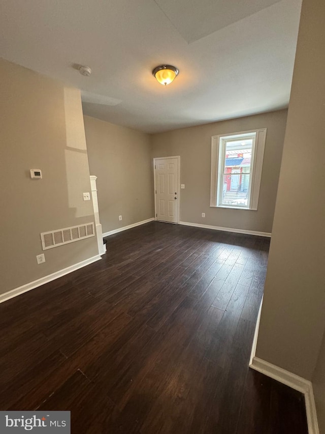 spare room featuring dark wood-type flooring