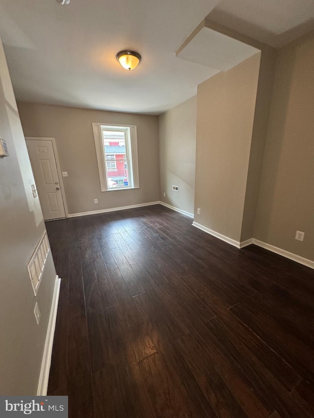 spare room with dark wood-type flooring