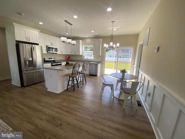 kitchen with pendant lighting, a center island, white cabinetry, and stainless steel appliances