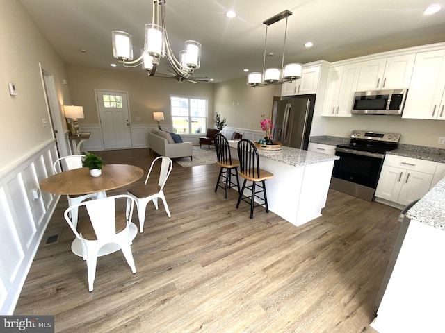 kitchen featuring white cabinetry, hanging light fixtures, and appliances with stainless steel finishes