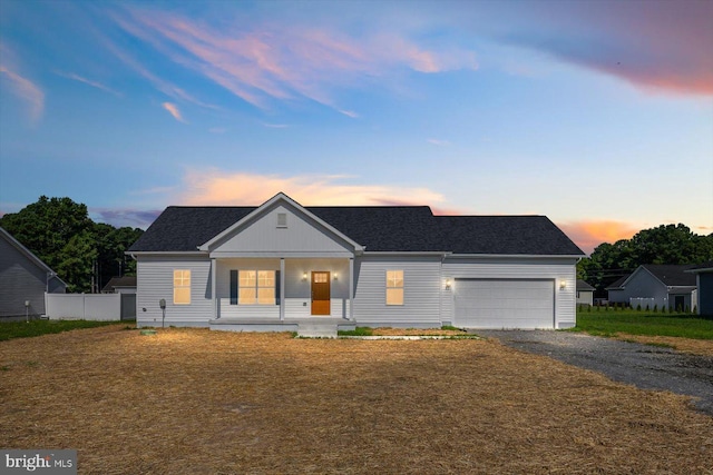 ranch-style home featuring covered porch and a garage