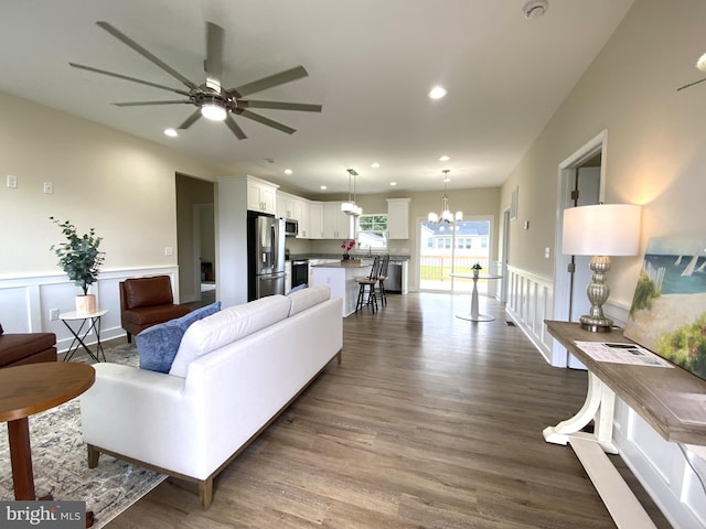 living room with hardwood / wood-style floors and ceiling fan with notable chandelier