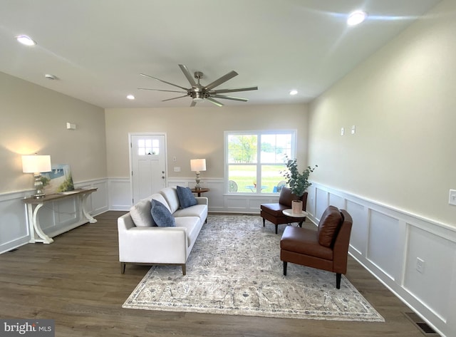 living room featuring ceiling fan and dark hardwood / wood-style floors