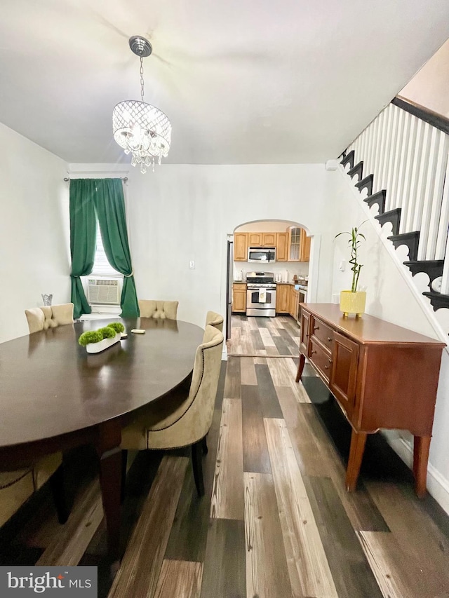 dining space with dark hardwood / wood-style floors, cooling unit, and a chandelier