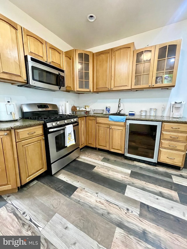 kitchen featuring dark wood-type flooring, sink, beverage cooler, and appliances with stainless steel finishes