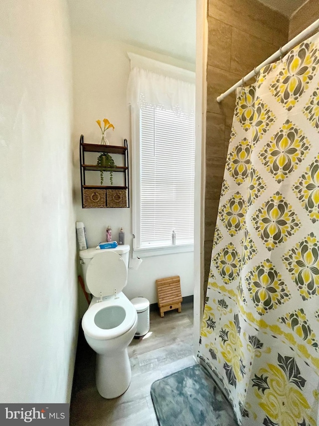 bathroom with toilet, wood-type flooring, and walk in shower