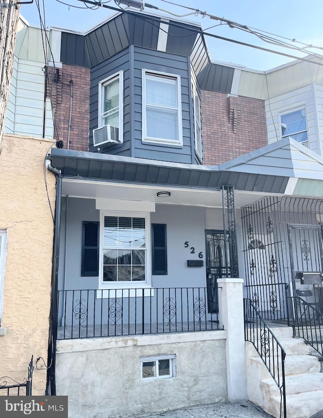 view of front of property with a porch and cooling unit