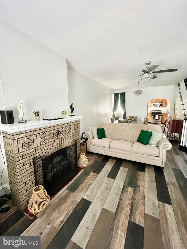 living room featuring a fireplace, wood-type flooring, and ceiling fan