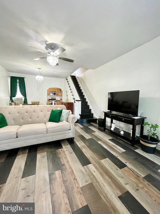 living room featuring hardwood / wood-style flooring and ceiling fan with notable chandelier