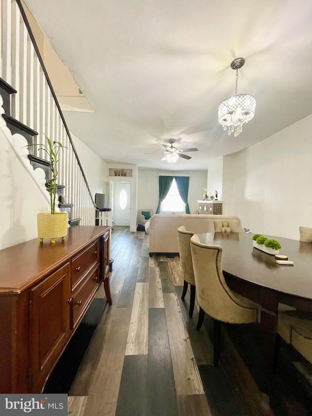 dining room with dark hardwood / wood-style flooring and ceiling fan with notable chandelier