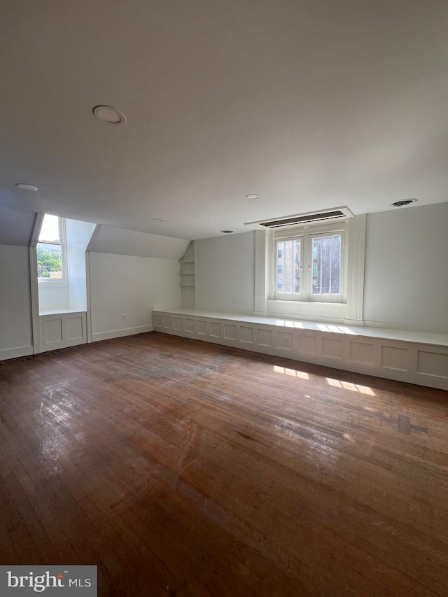 bonus room with dark hardwood / wood-style floors and vaulted ceiling