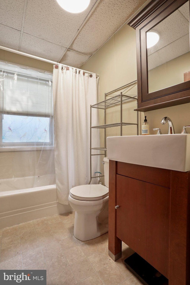 full bathroom featuring vanity, a paneled ceiling, toilet, and shower / bath combo with shower curtain