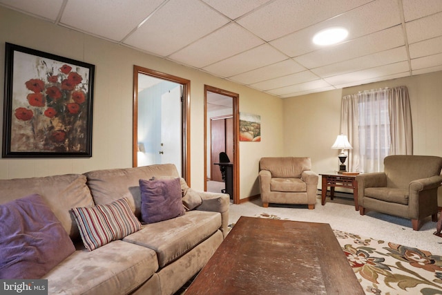 carpeted living room with a drop ceiling