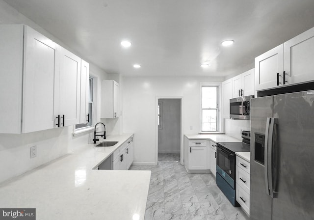 kitchen with sink, white cabinetry, and stainless steel appliances