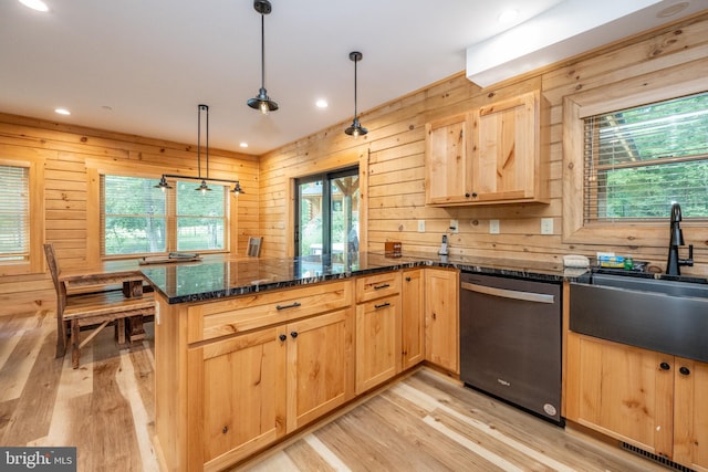 kitchen with dishwasher, sink, hanging light fixtures, kitchen peninsula, and dark stone countertops