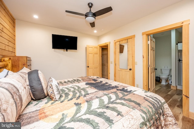 bedroom featuring ceiling fan, wood-type flooring, and ensuite bath