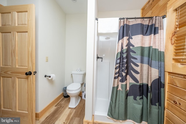 bathroom featuring hardwood / wood-style floors, curtained shower, and toilet