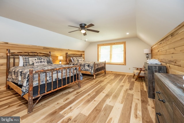 bedroom with hardwood / wood-style floors, ceiling fan, lofted ceiling, and wood walls