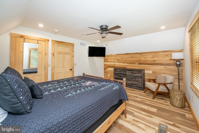 bedroom with ceiling fan, vaulted ceiling, and hardwood / wood-style flooring