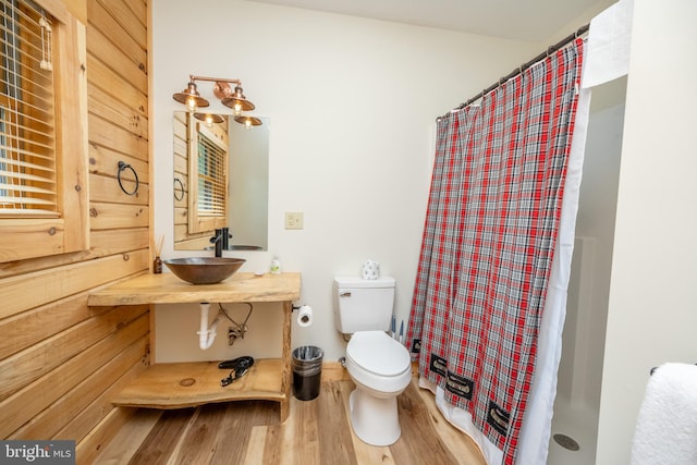 bathroom featuring hardwood / wood-style flooring, curtained shower, toilet, and sink