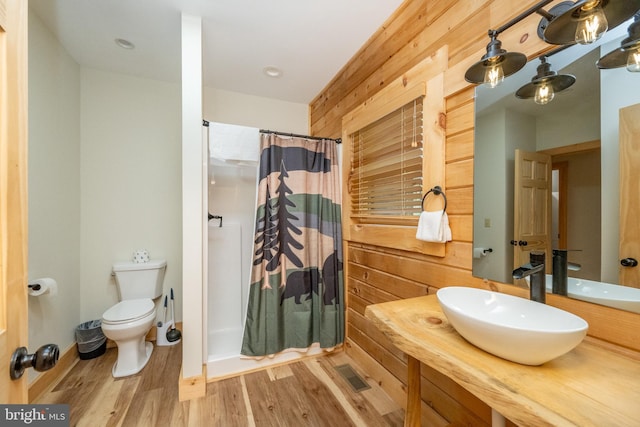 bathroom featuring wood-type flooring, a shower with curtain, toilet, and sink