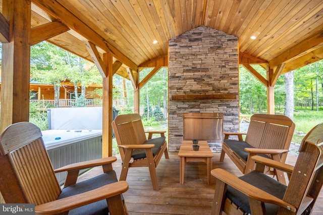 view of patio featuring an outdoor stone fireplace and a deck