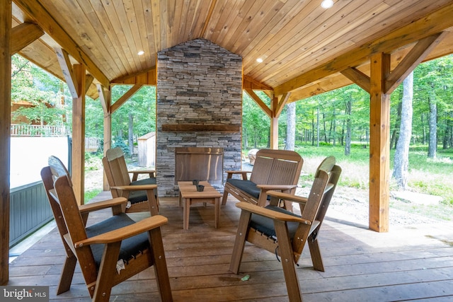 view of patio / terrace with an outdoor stone fireplace and a deck