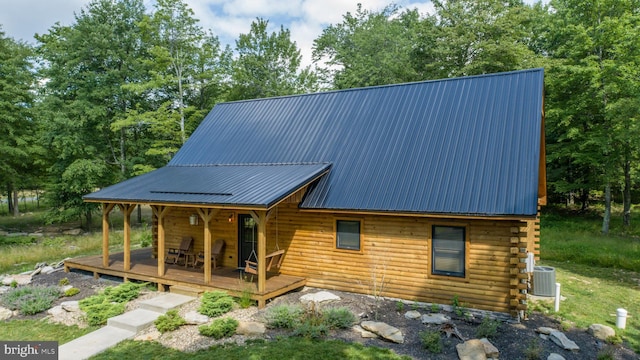 rear view of house featuring cooling unit, covered porch, and a deck