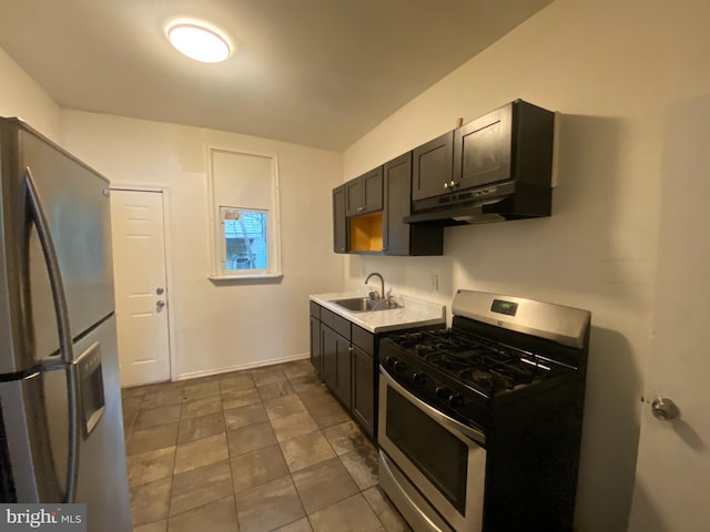 kitchen with gas stove, stainless steel fridge, and sink