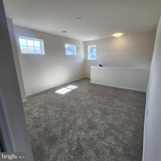 carpeted spare room featuring a wealth of natural light