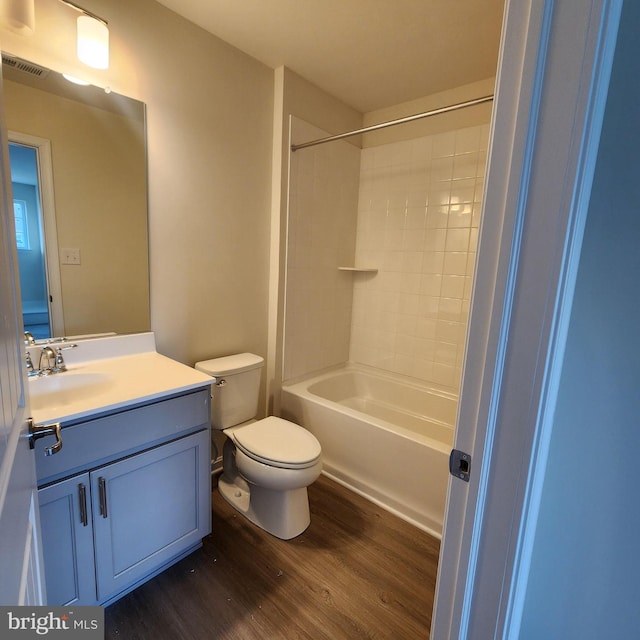 full bathroom with toilet, hardwood / wood-style floors, vanity, and shower / bathing tub combination