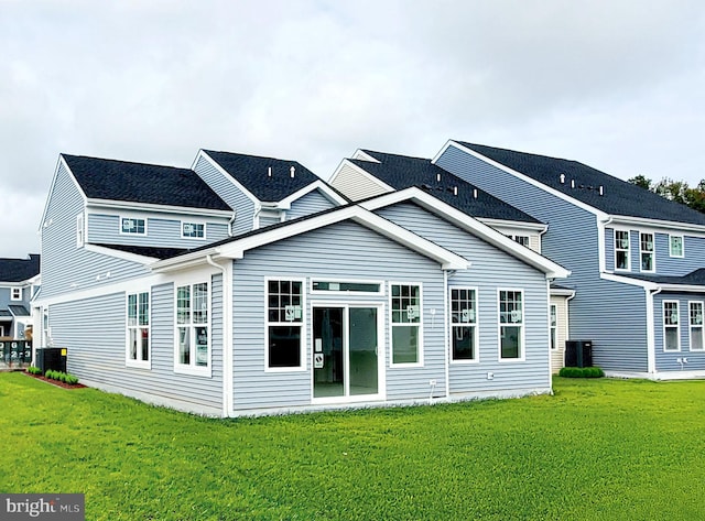 back of property featuring central AC unit and a lawn