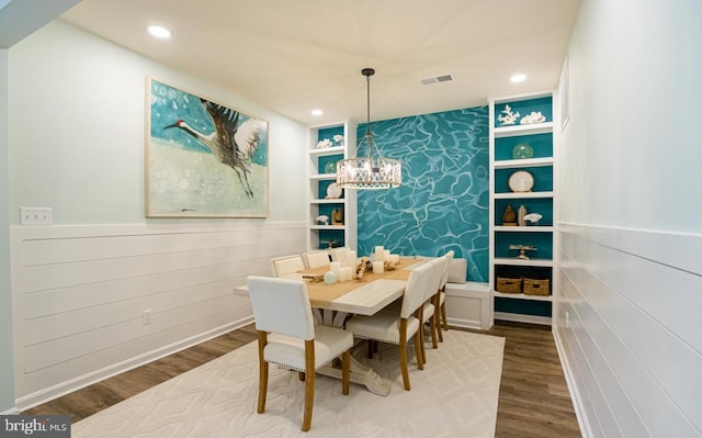 dining room with wood-type flooring and built in features