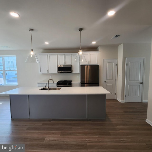 kitchen with pendant lighting, sink, white cabinetry, and stainless steel appliances