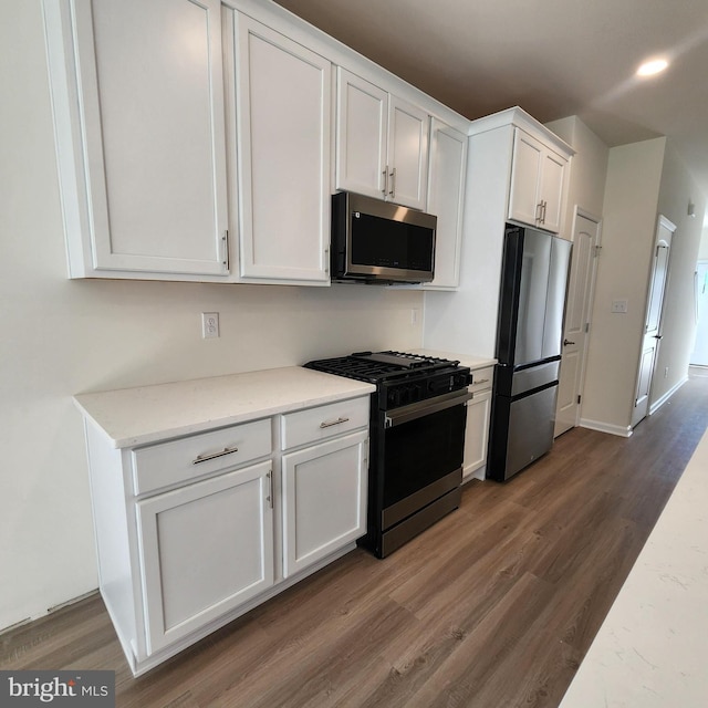 kitchen featuring dark wood-type flooring, white cabinets, and stainless steel appliances