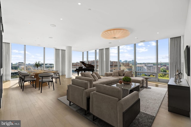 living room with light hardwood / wood-style floors and a wall of windows