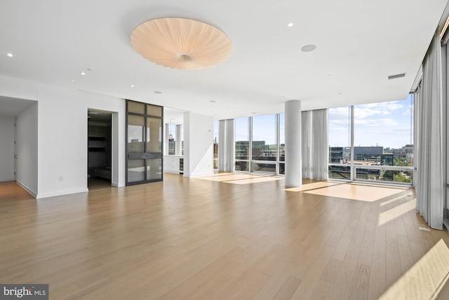 unfurnished living room with light hardwood / wood-style floors and floor to ceiling windows