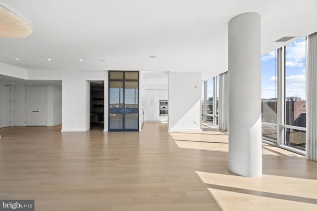 unfurnished living room featuring light hardwood / wood-style floors and expansive windows