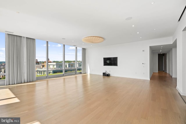 unfurnished living room featuring light hardwood / wood-style flooring and a wall of windows