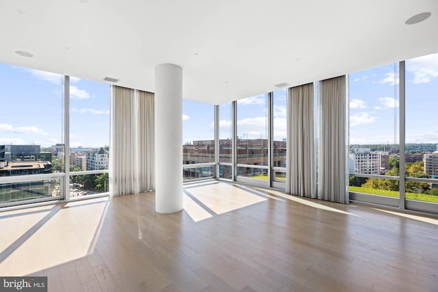 spare room with wood-type flooring and floor to ceiling windows