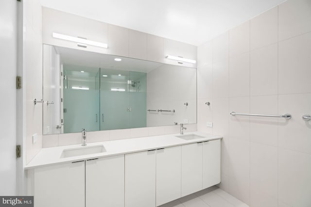 bathroom featuring an enclosed shower, vanity, tile patterned floors, and tile walls