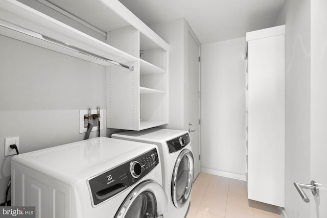 clothes washing area featuring separate washer and dryer and light tile patterned floors