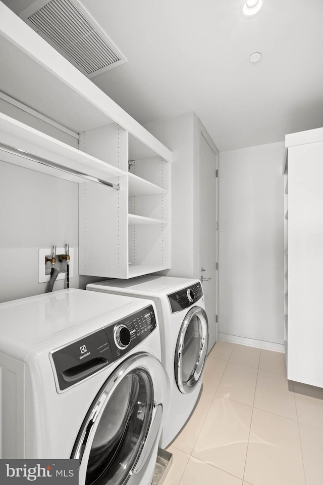 laundry room with separate washer and dryer and light tile patterned flooring