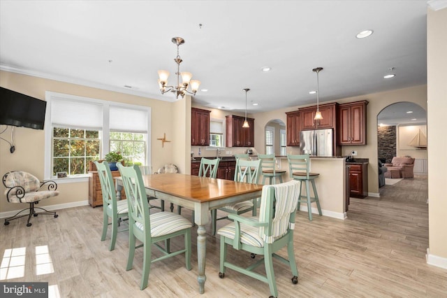 dining room with light hardwood / wood-style flooring and an inviting chandelier