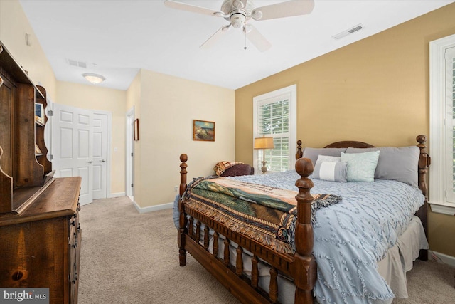 bedroom with a closet, ceiling fan, and light carpet