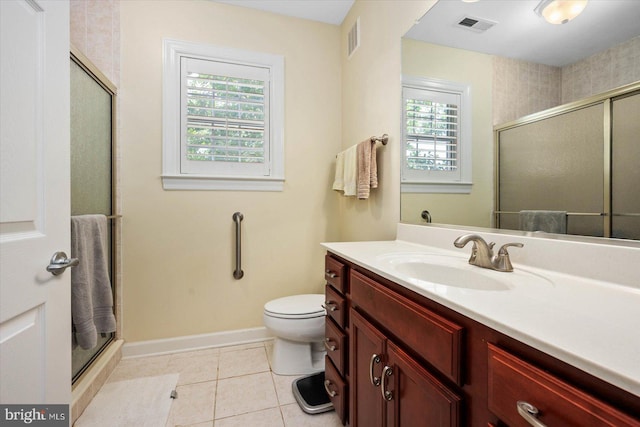 bathroom with tile patterned flooring, toilet, a healthy amount of sunlight, and a shower with door