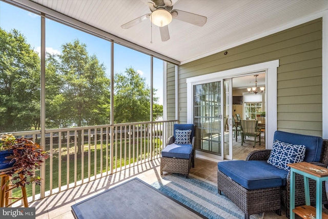 sunroom with plenty of natural light and ceiling fan with notable chandelier