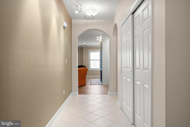 hall with light hardwood / wood-style flooring and track lighting