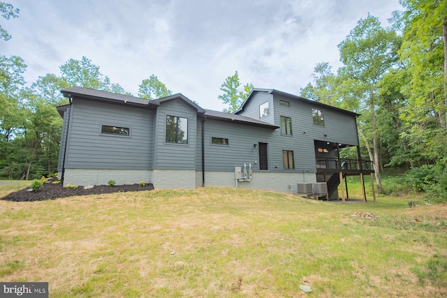 exterior space featuring stairs, a lawn, and a wooden deck