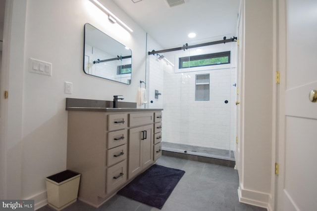 bathroom featuring a stall shower, vanity, and baseboards